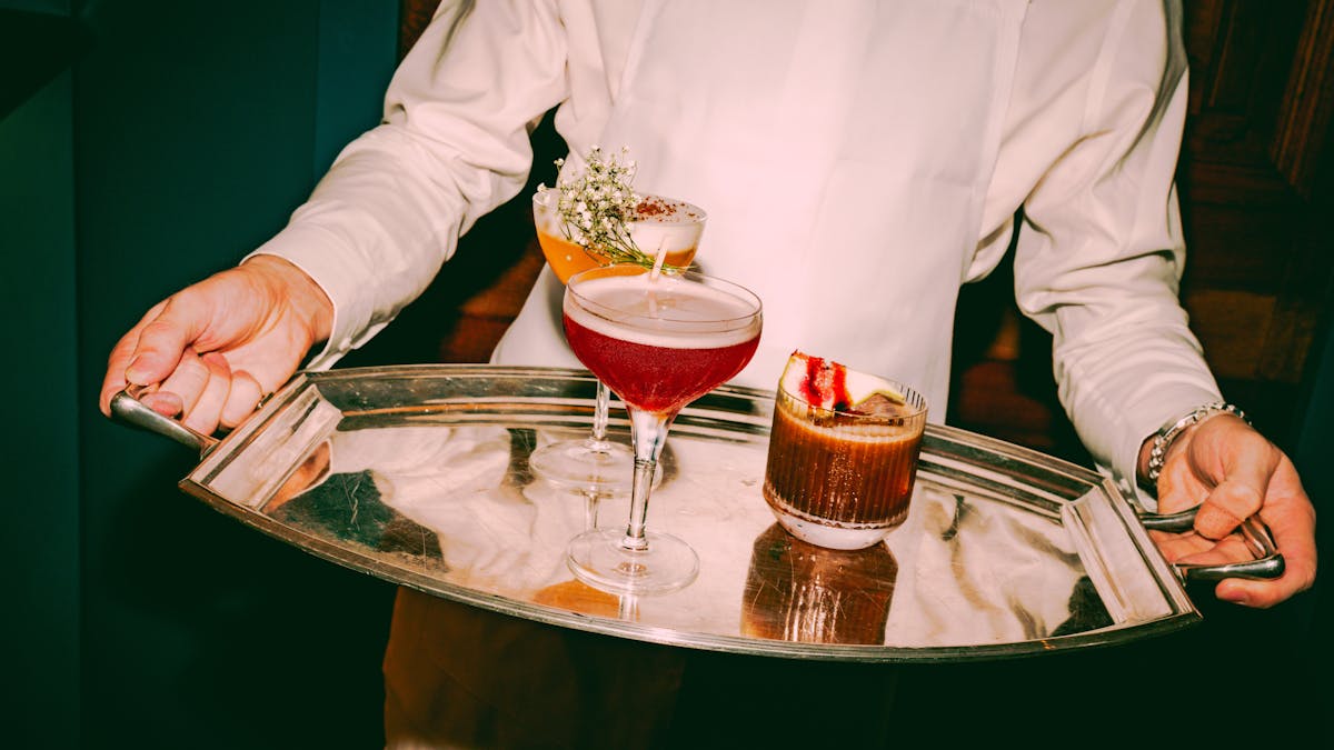 A silver tray with two lovely cocktails on it