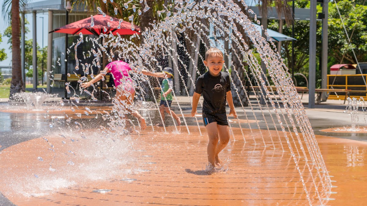 Little boy running through a water in the East Shores Water play park