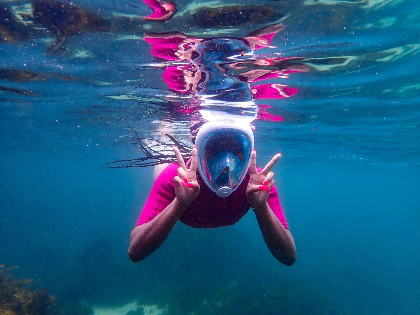 Happy snorkeller in the water wearing a full face snorkeling mask