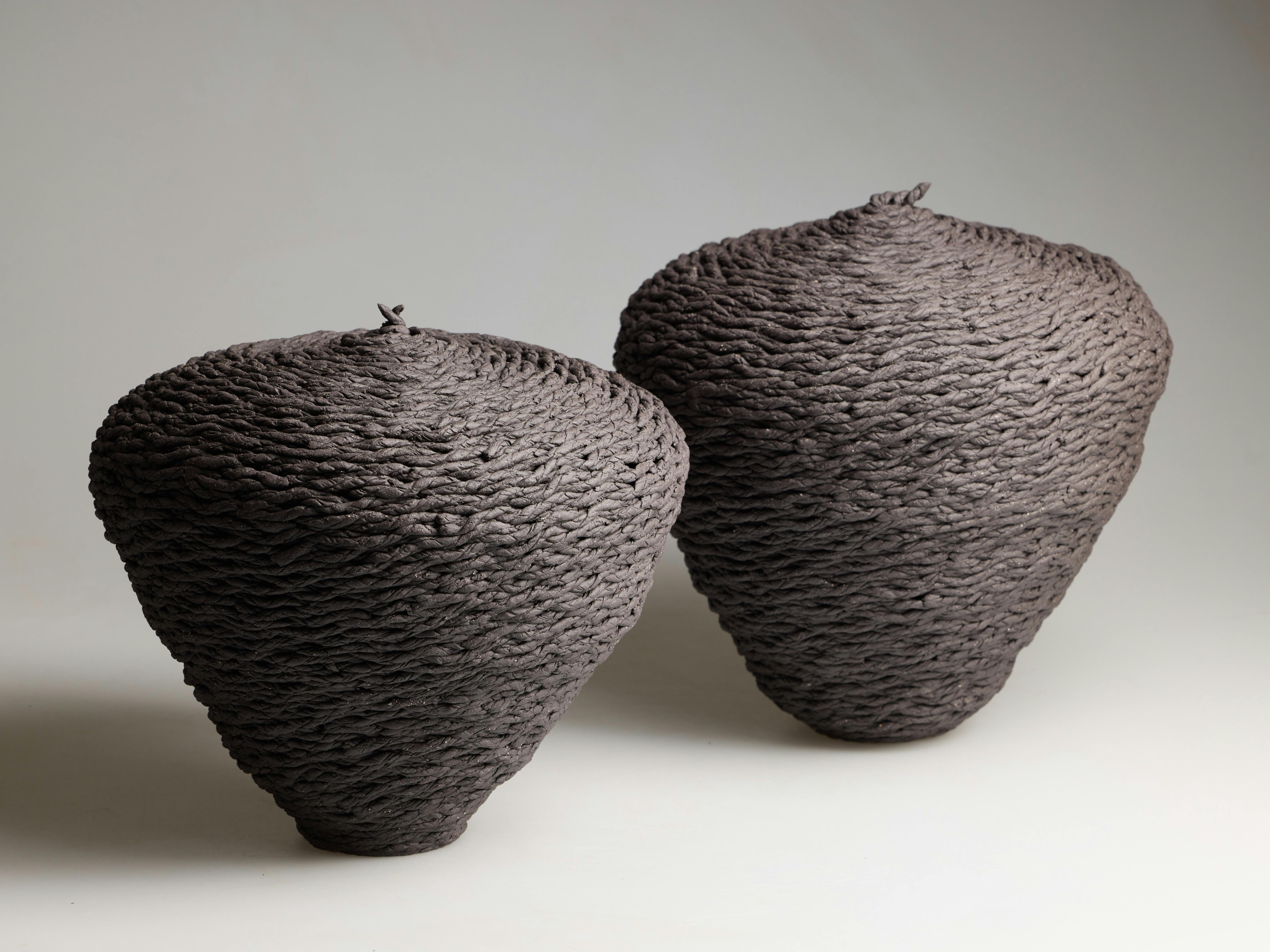 Julie Pennington, Encircle 2 & 3, 2026, dark matter clay, 27.5 x 29 x 29cm and 31 x 29 x 29 cm