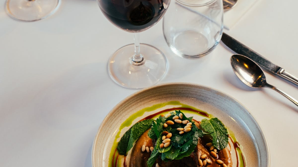 dining table with a plate of food and 2 glasses of wine
