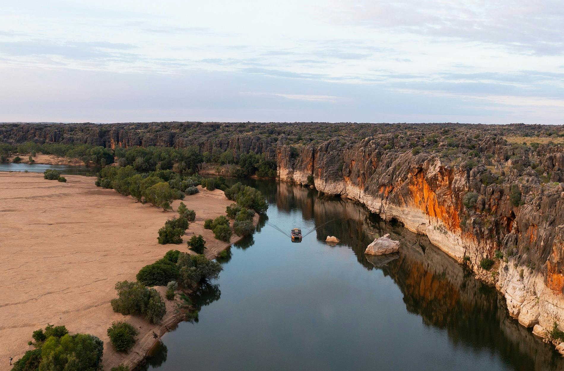 Aerial view of a boat cruising down Geikie Gorge, Wunaamin Miliwundi Ranges