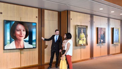 A person showing a portrait to a family of three