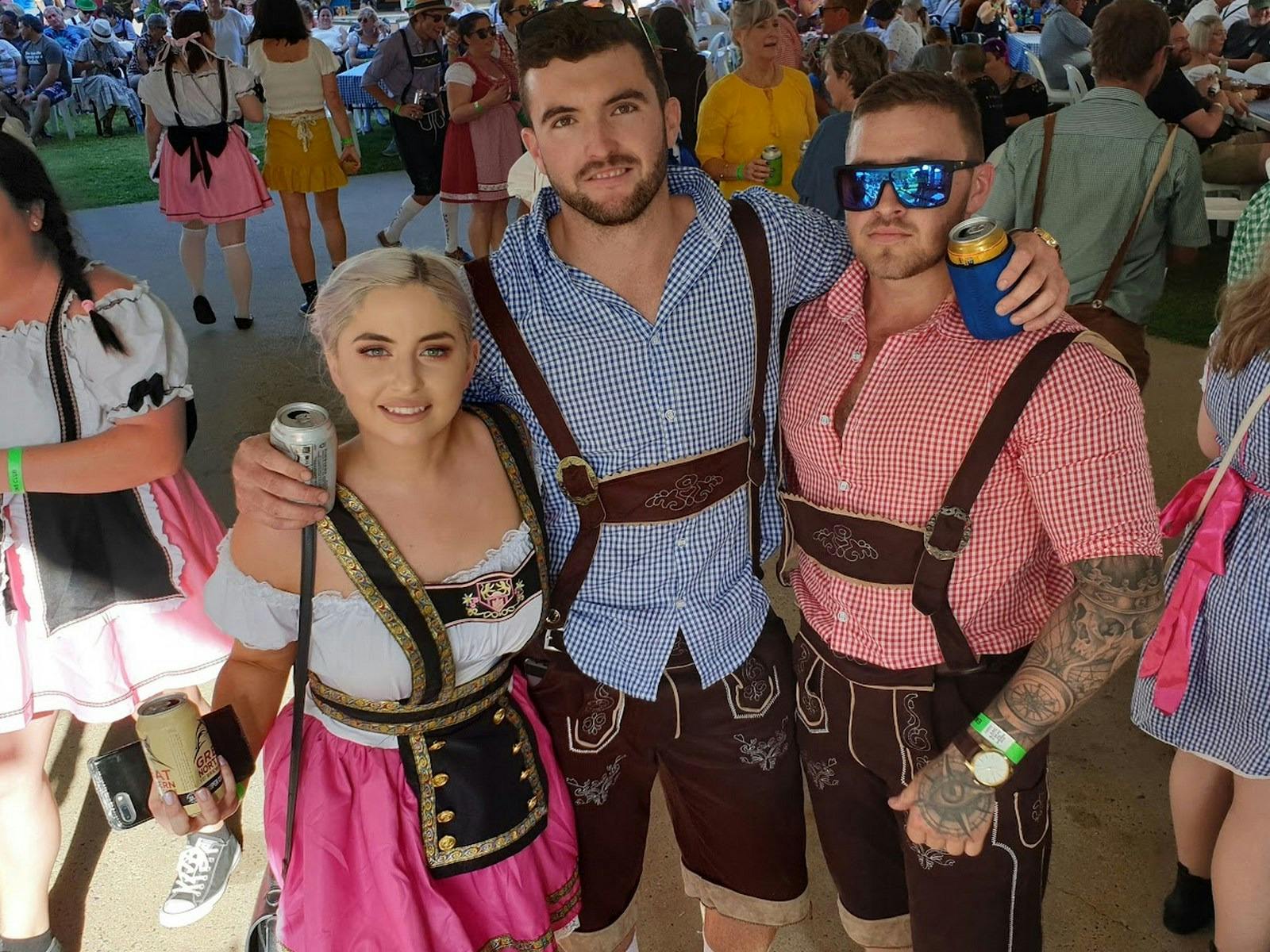 Two guys and a gal dressed in traditional Bavarian costume