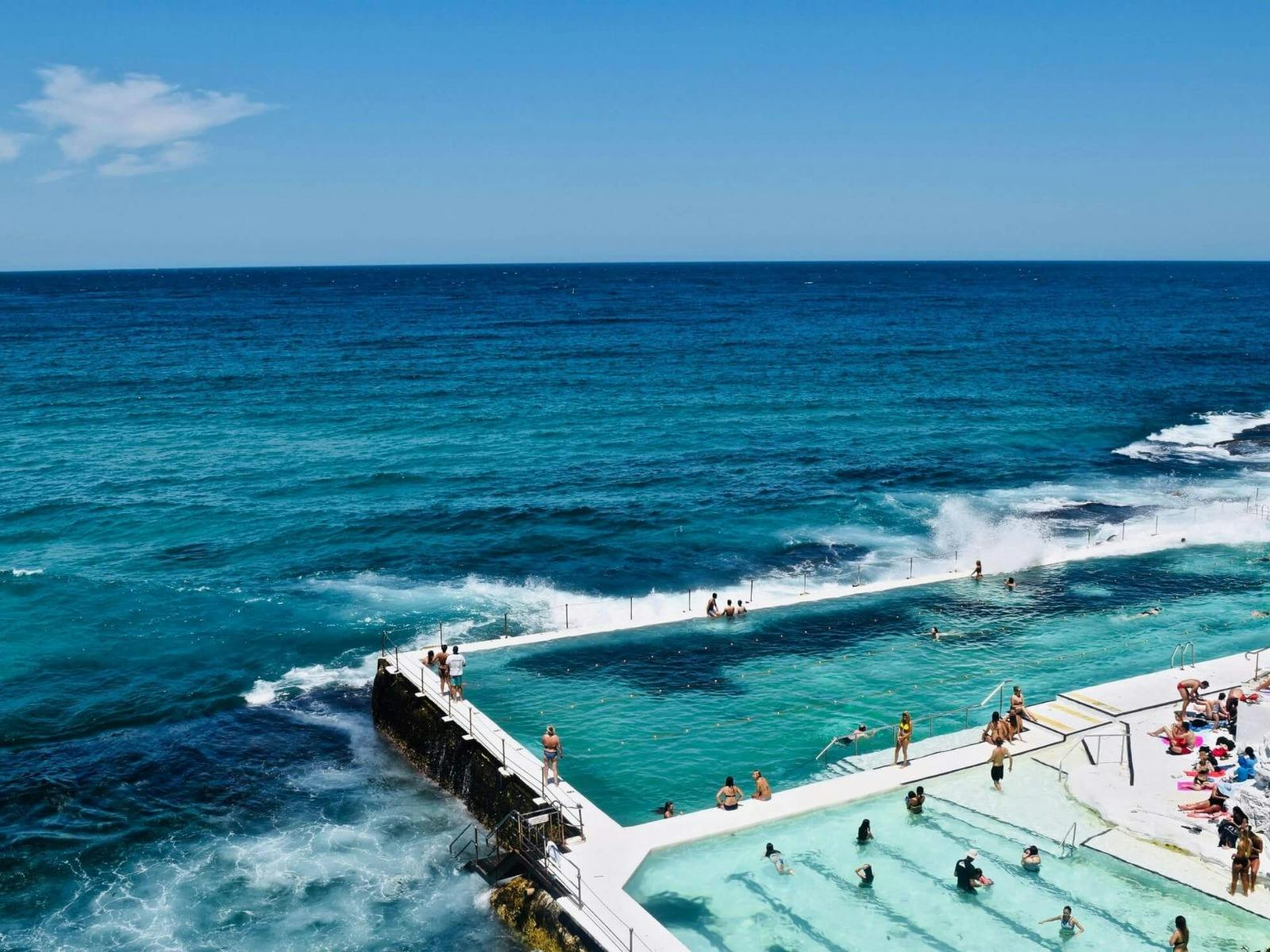 Bondi Icebergs ocean pool packed with swimmers, waves crashing over the edge, Sydney