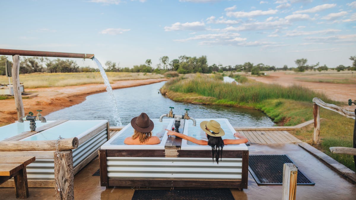 Two people sitting in Hot artesian baths at Charlotte Plains, Outback Queensland