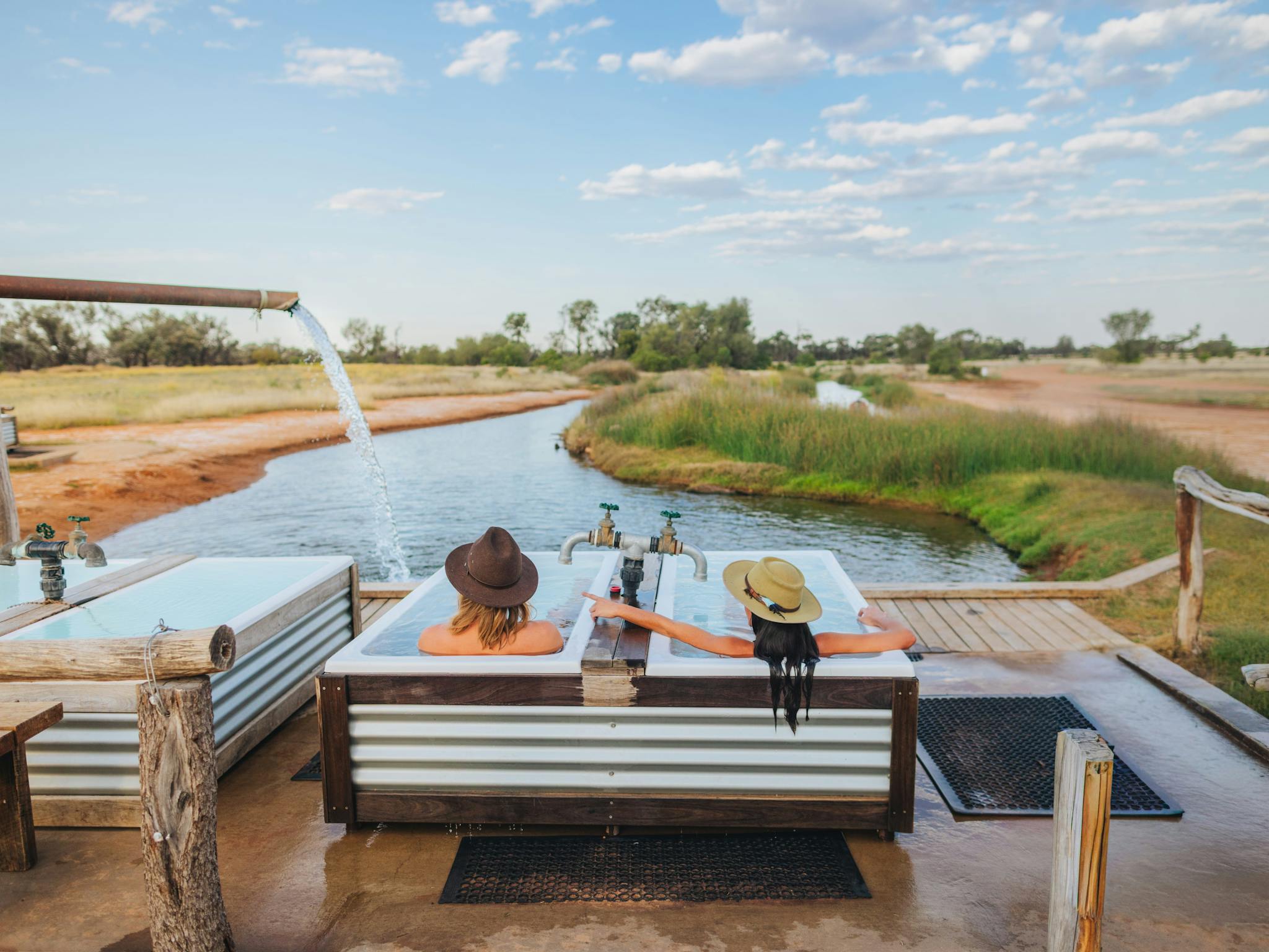 Two people sitting in Hot artesian baths at Charlotte Plains, Outback Queensland Two people sitting in Hot artesian baths at Charlotte Plains, Outback Queensland