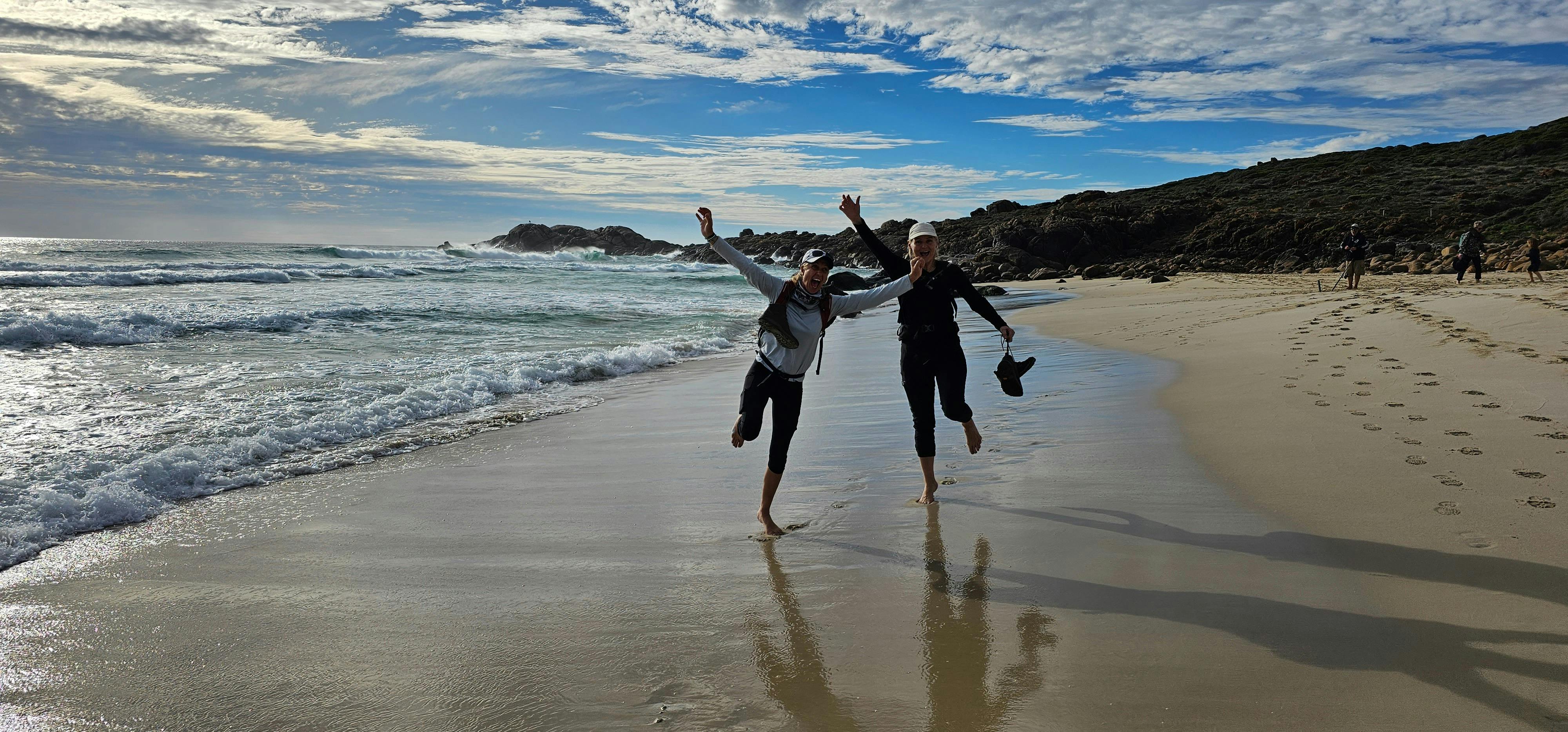 Happy hikers with no shoes on walking in water at Smith's Beach