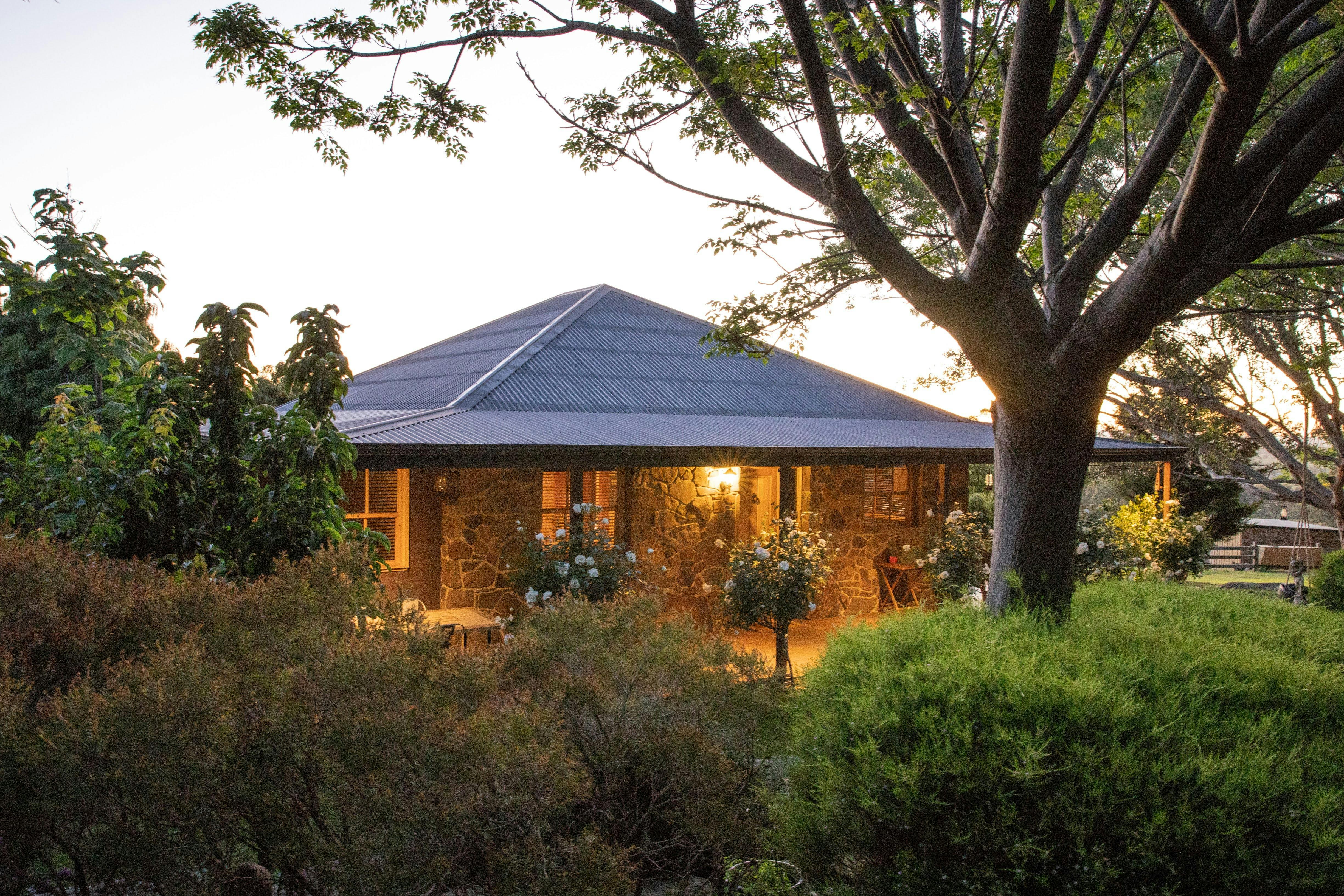 Beautiful outdoor lighting at Stone Creek Cottage with established garden
