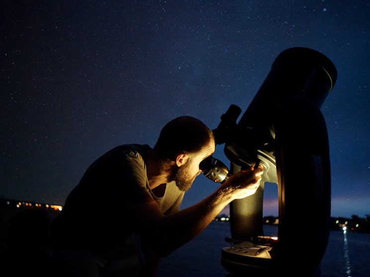 Man looking through a high powered telescope