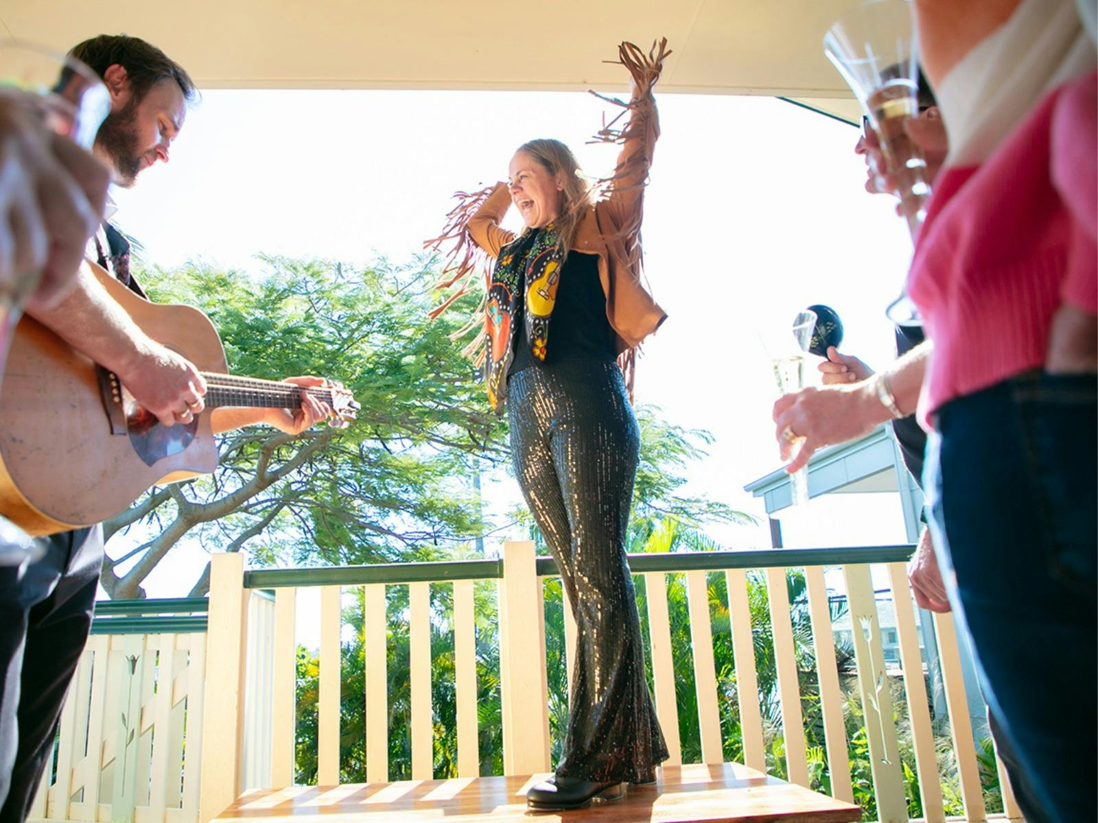 Miss Jacquie singing and a guitarist playing and people drinking