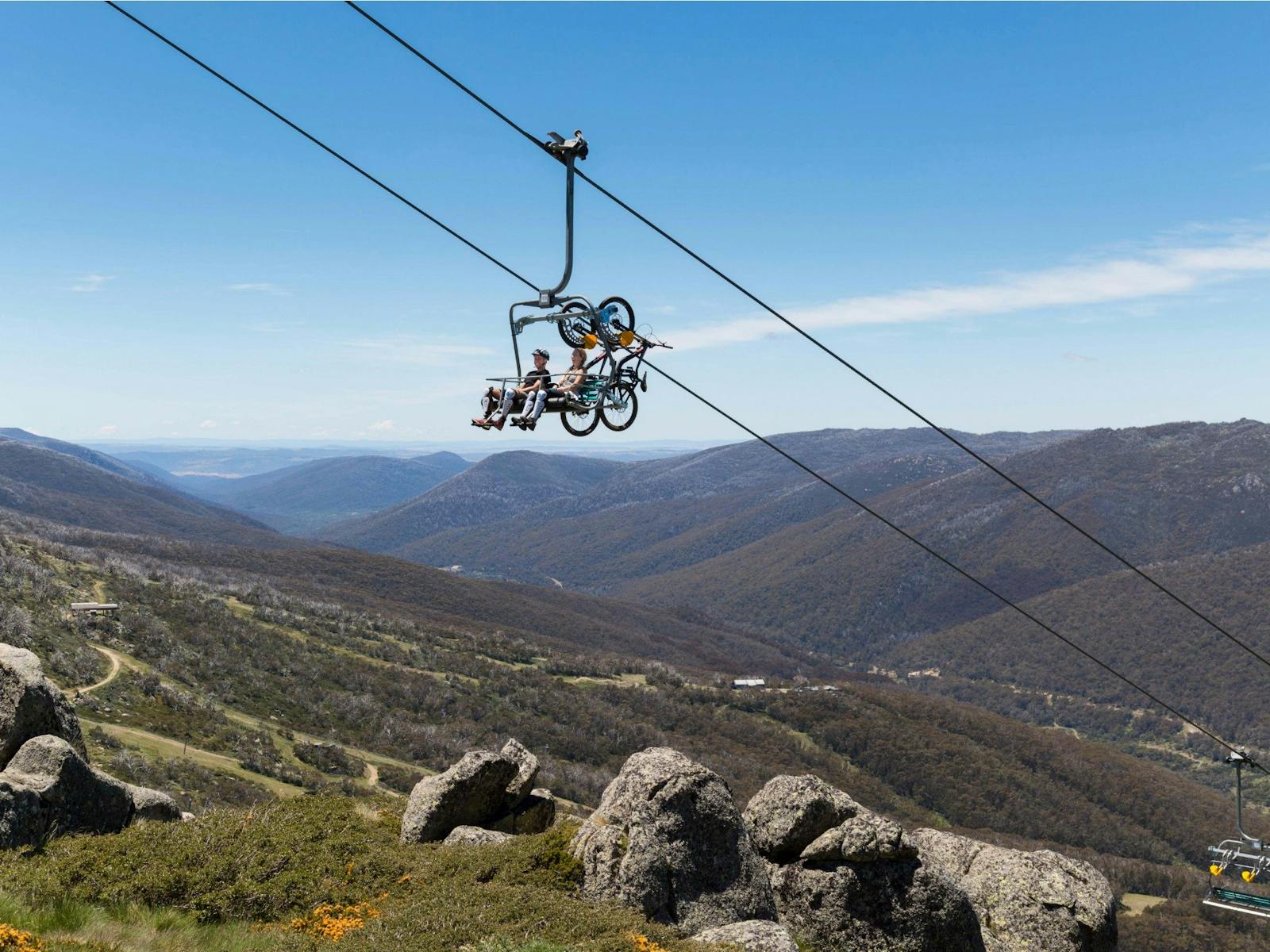 Mountainbiker, die mit einem Sessellift an die Spitze des Thredbo Valley Track fahren