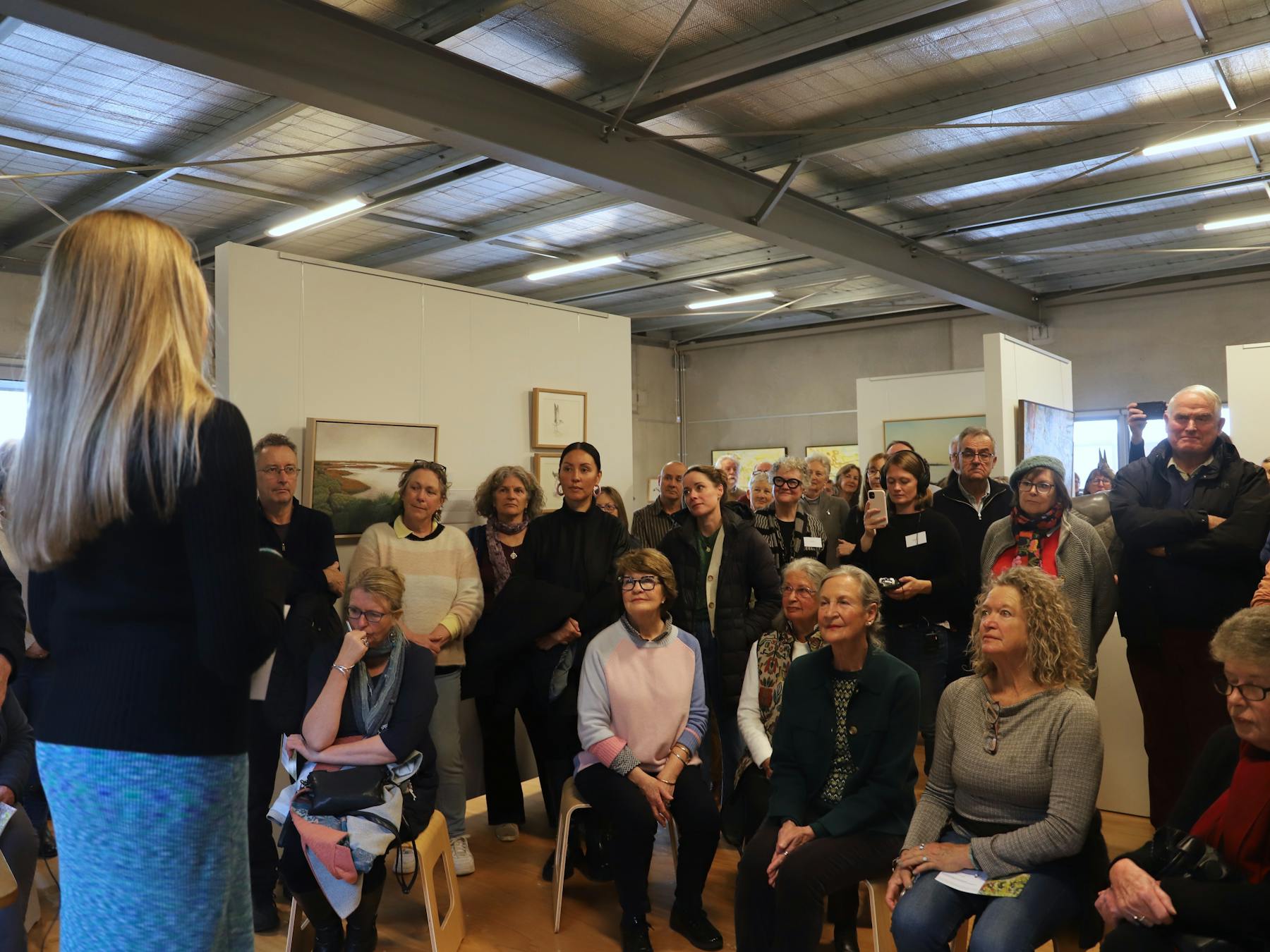 Large crowd listening to artist Jane Millington talk at wetlands exhibition opening