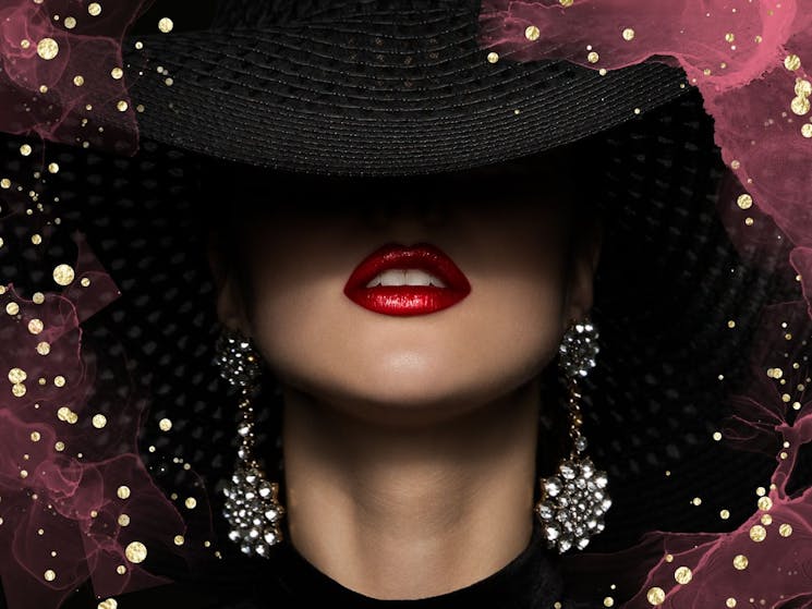 A half-concealed face of a women with red lipstick and large earrings covered in darkness and stars