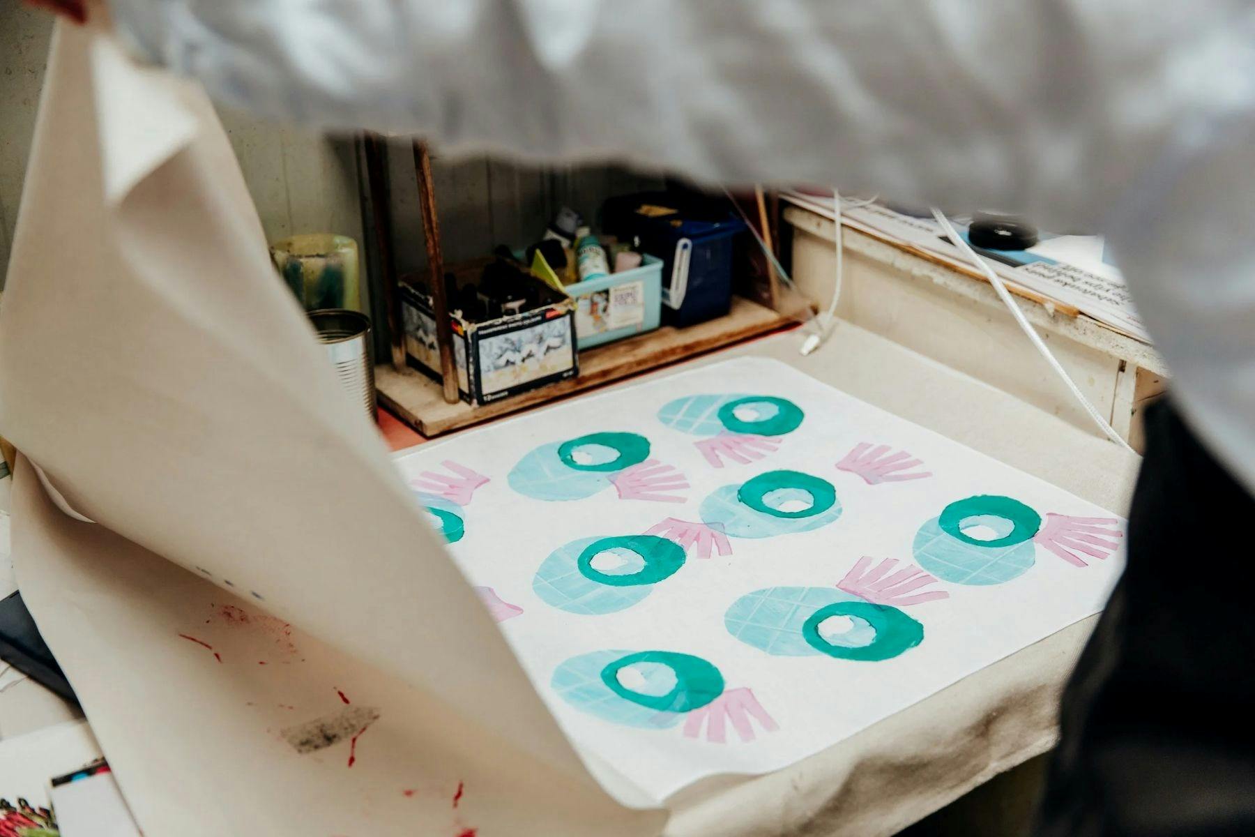 A photo of a textile print using stamps in round shapes in blue and pink