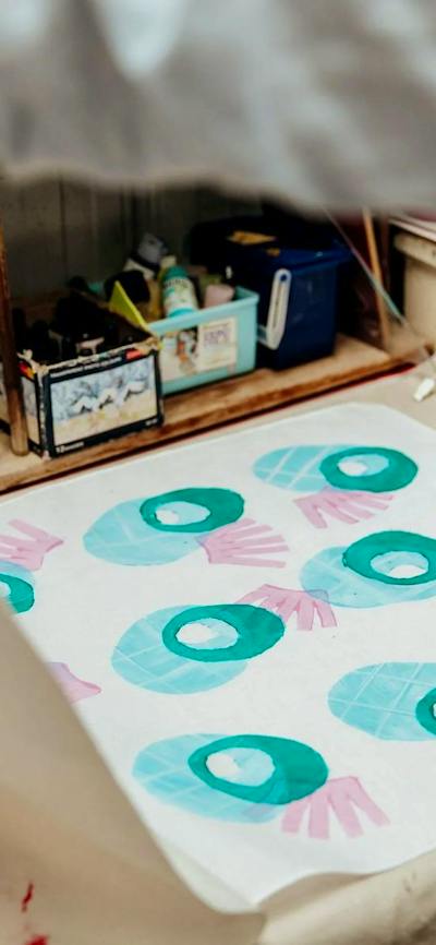 A photo of a textile print using stamps in round shapes in blue and pink