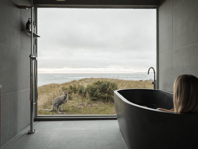 Hand made concrete bath tub with panoramic views through a wall of glass, relax surrounded by nature