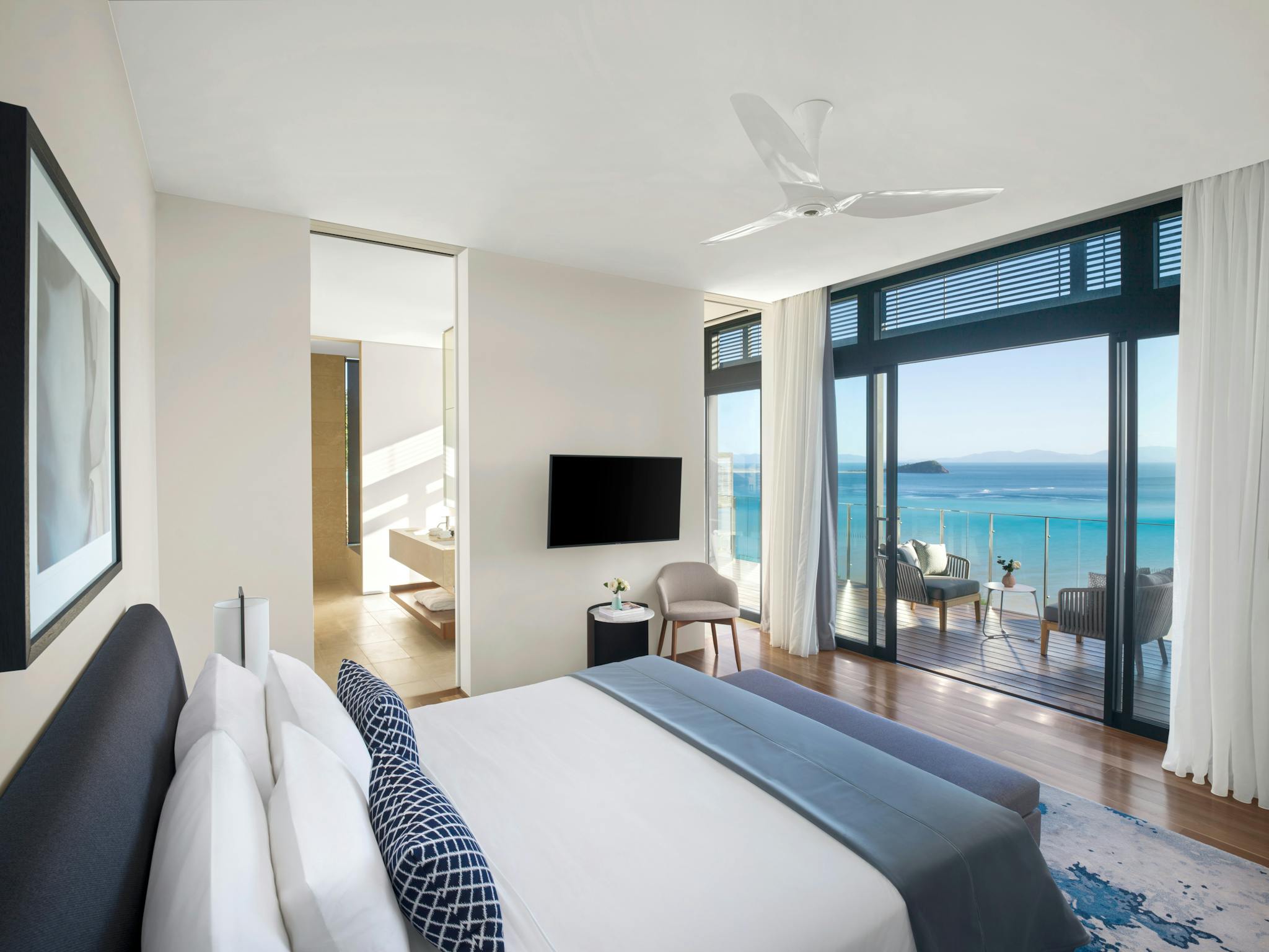A stylish bedroom with a king-sized bed, ocean-view balcony, glass doors, and contemporary decor. A stylish bedroom with a king-sized bed, ocean-view balcony, glass doors, and contemporary decor.
