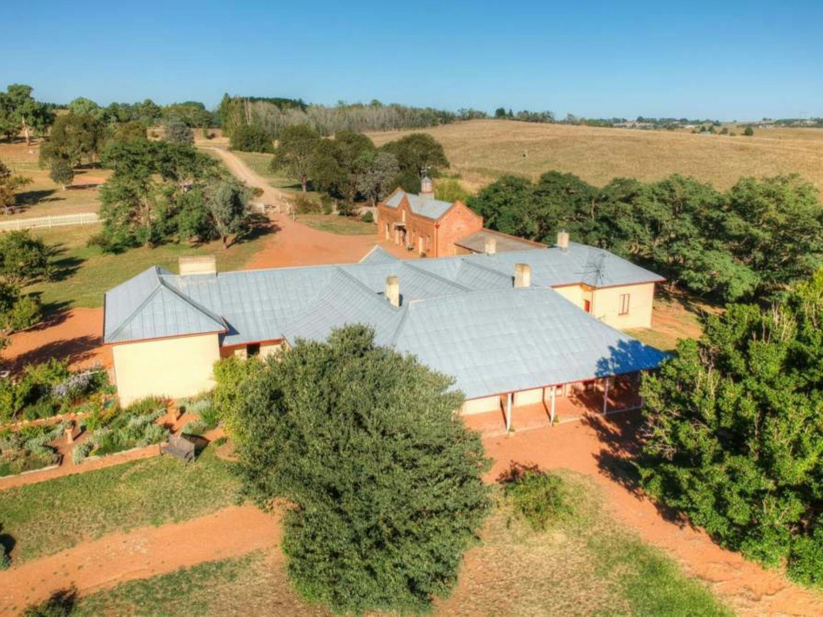 Aerial view of a sprawling historic building surrounded by farmland and gardens