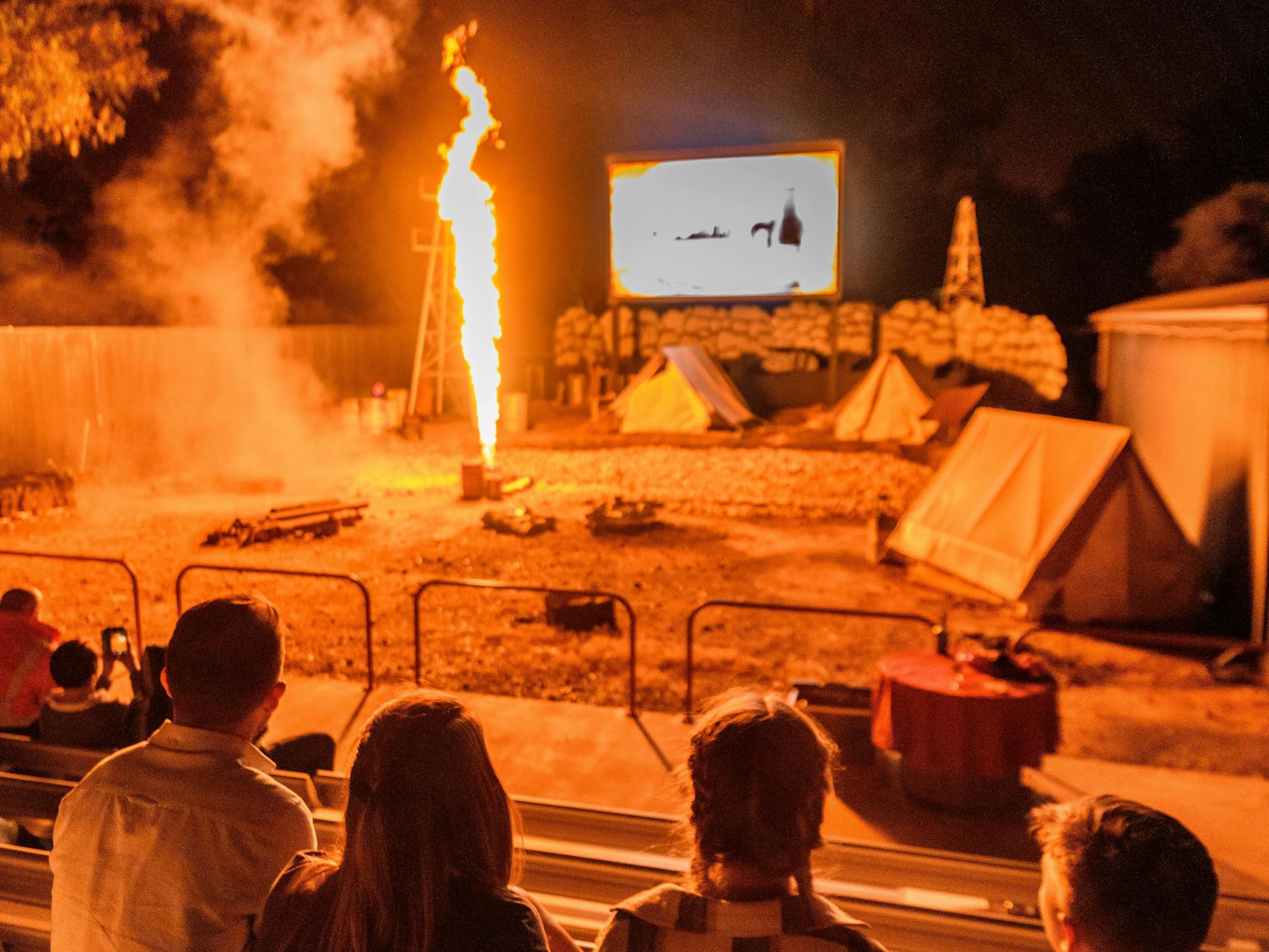 A family watching fire shoot from the ground during the Night Show A family watching fire shoot from the ground during the Night Show
