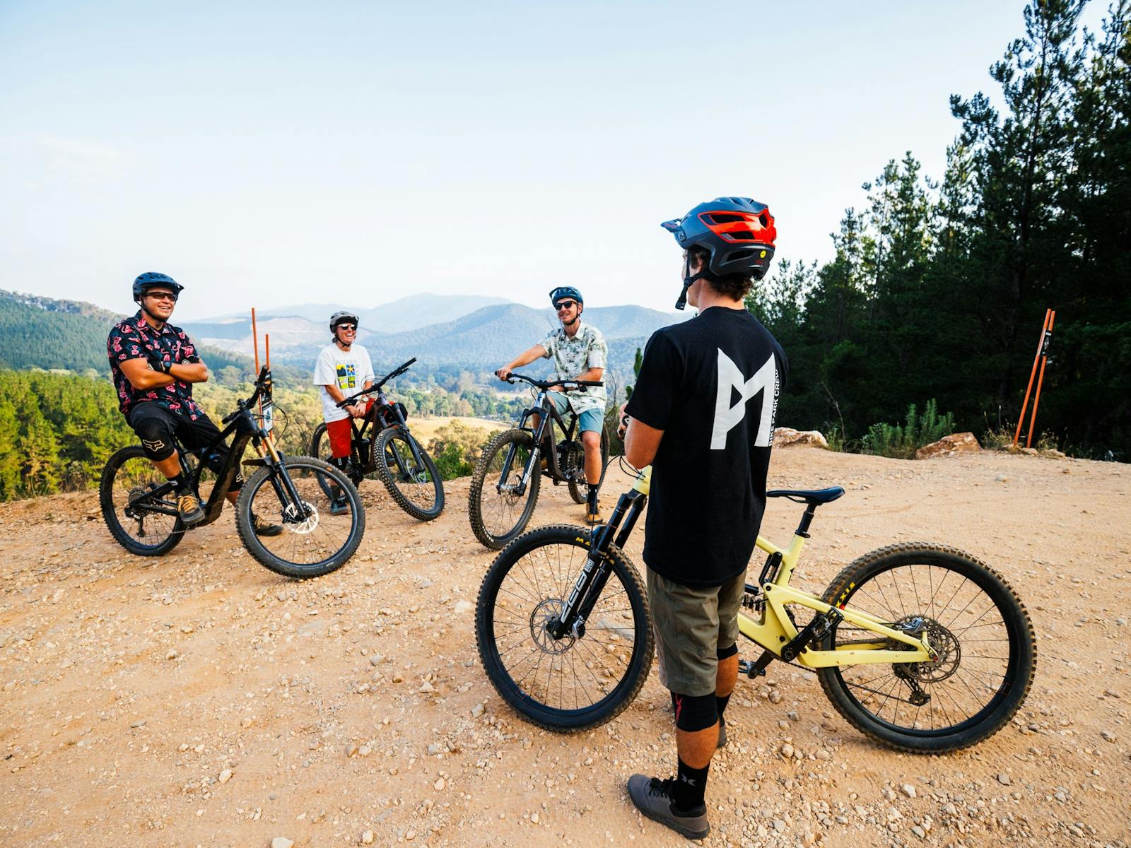 MTB riders smiling surrounded with mountain backdrop in Bright victoria