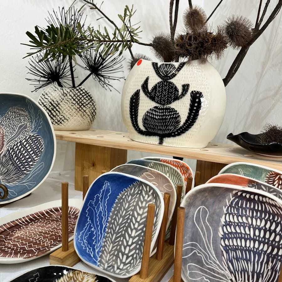 Image shows handmade decorated plates on a shelf