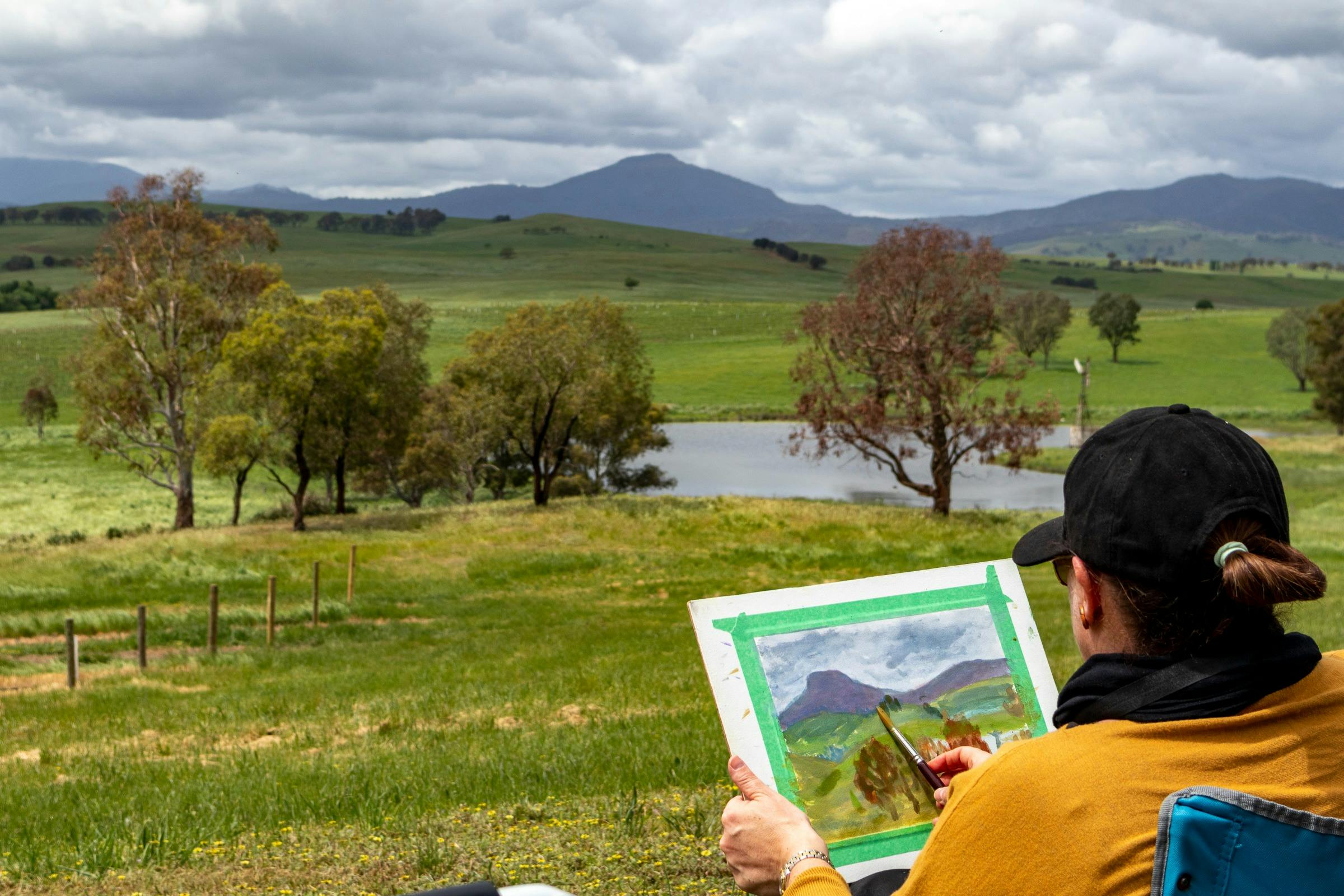 a woman paints the mountains