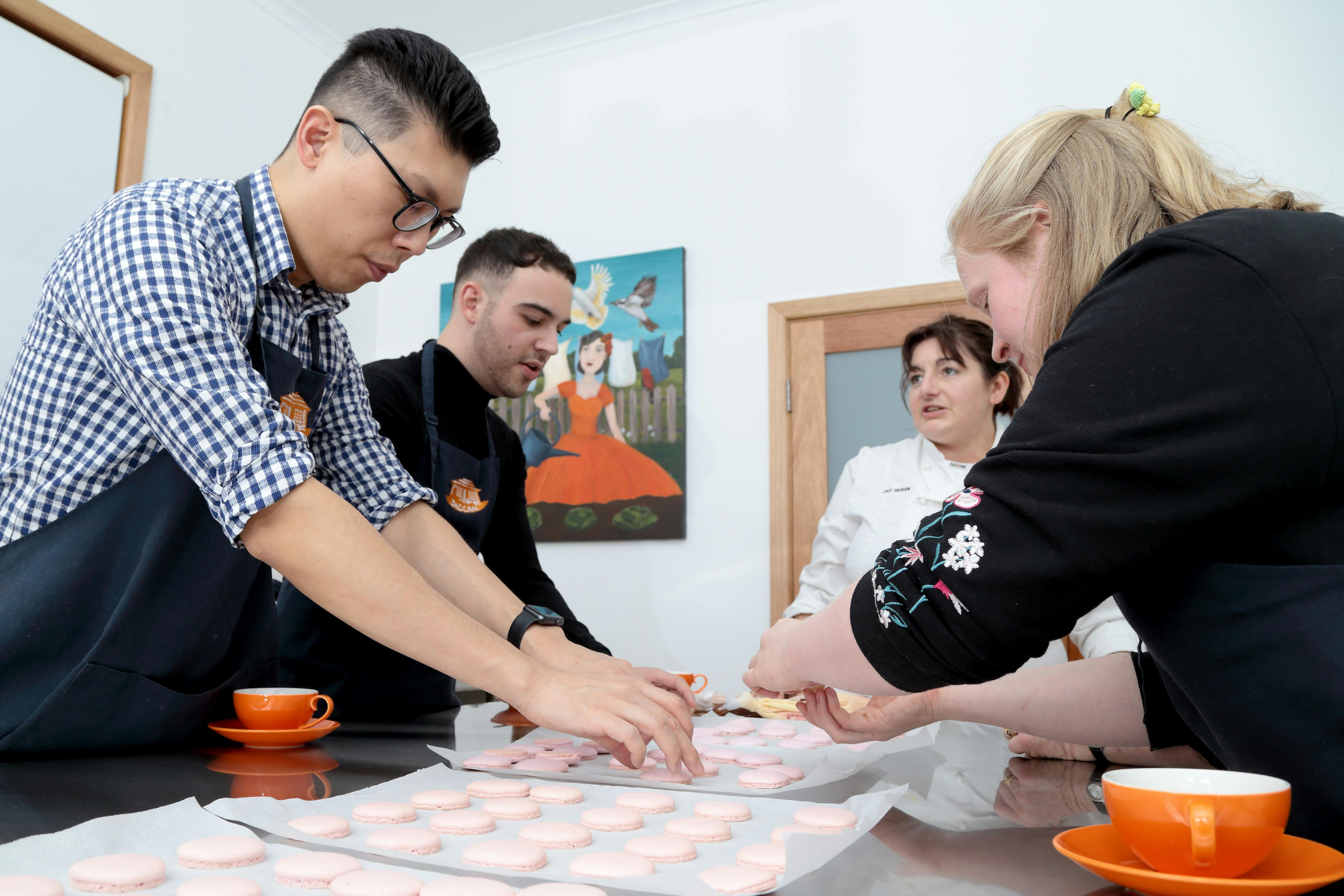 4 people making macarons together in the Jacican cooking school kitchen, Mirboo North, Gippsland