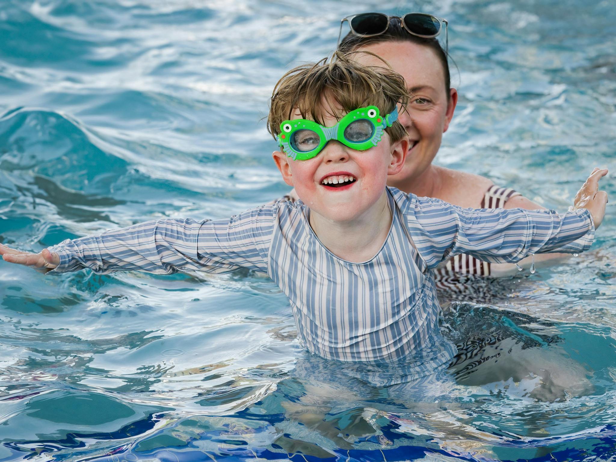 A child and adult in the swimming pool