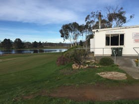 A shot of the club house and practise green with the lagoon in the distance