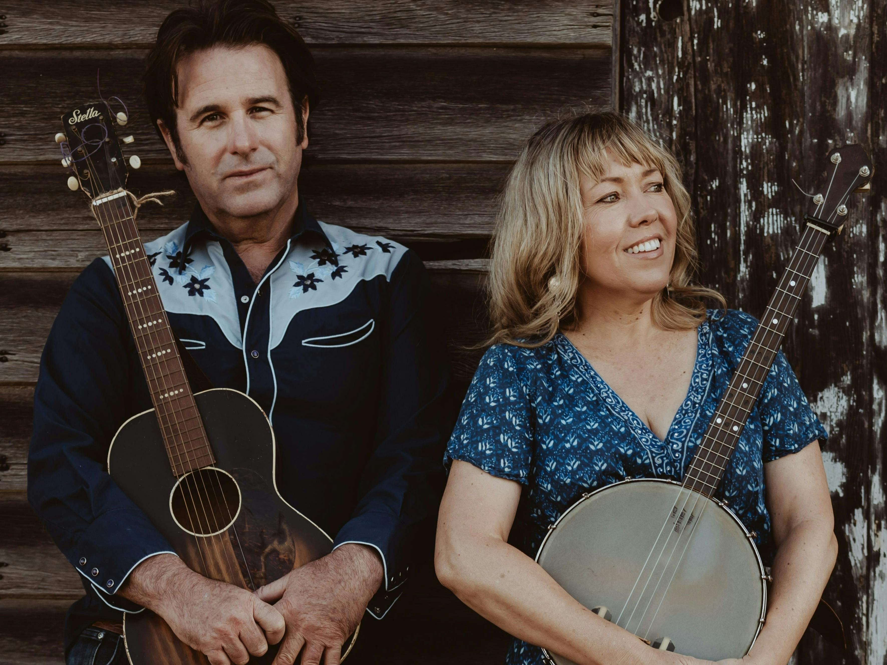 A man with a guitar and a woman with a banjo