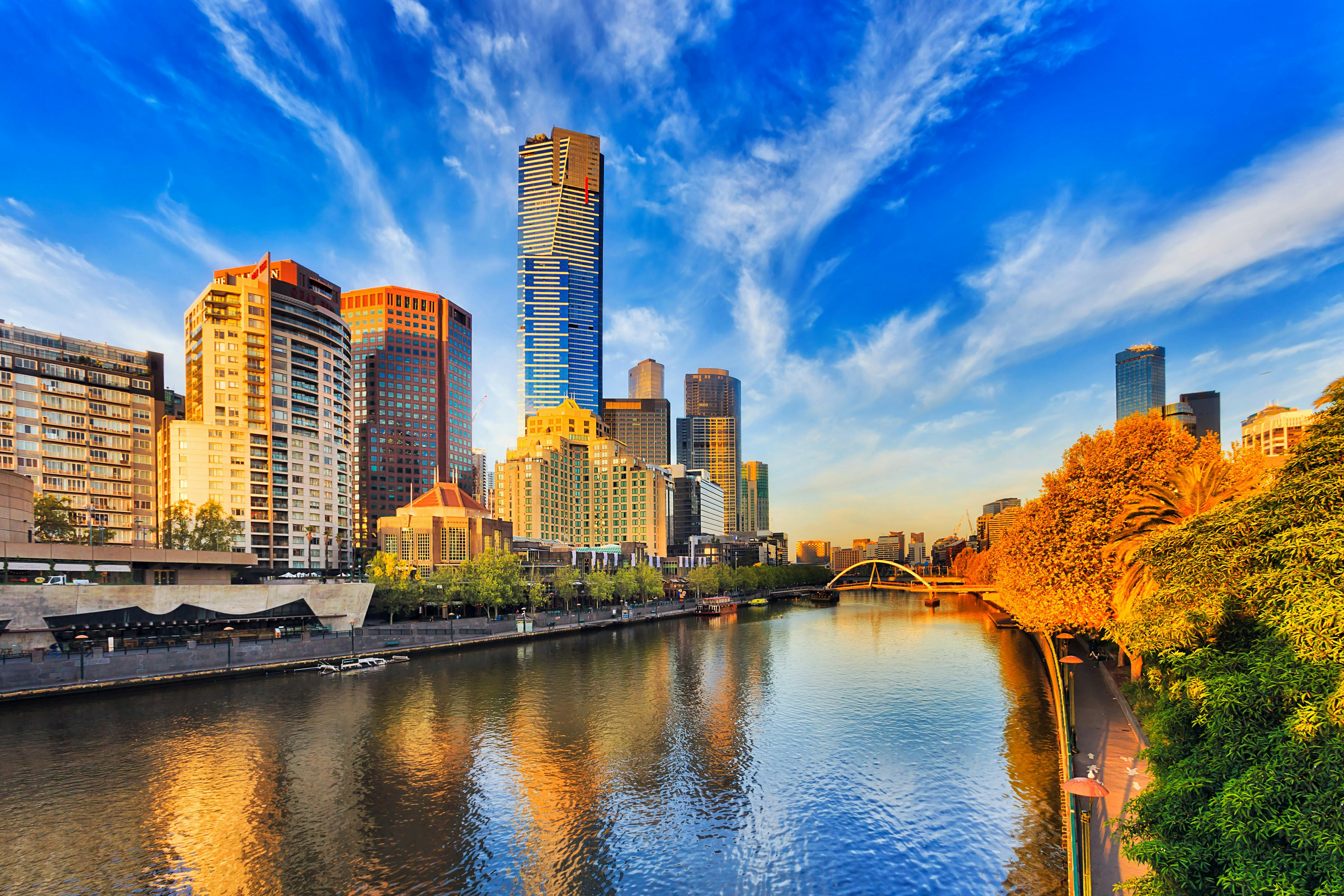 Melbourne skyline and Yarra River winding through, with blue sky