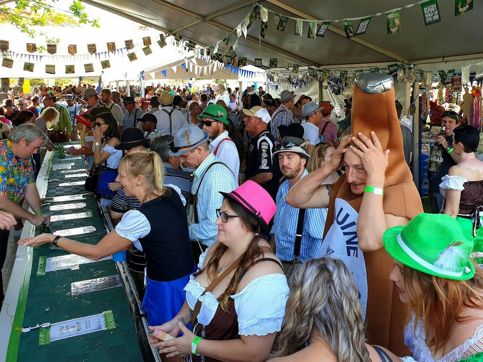 Group of patrons waiting and being served at the Oktoberfest bar.