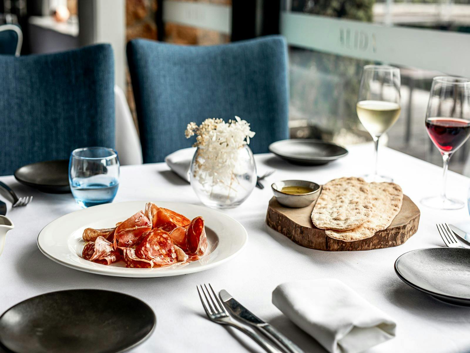 Freshly sliced charcuterie on white linen table