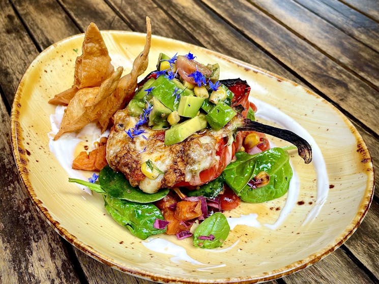 Mexican pork stuffed red pepper w/ avocado salsa, sour cream, spiced tortilla chips & sweet potato