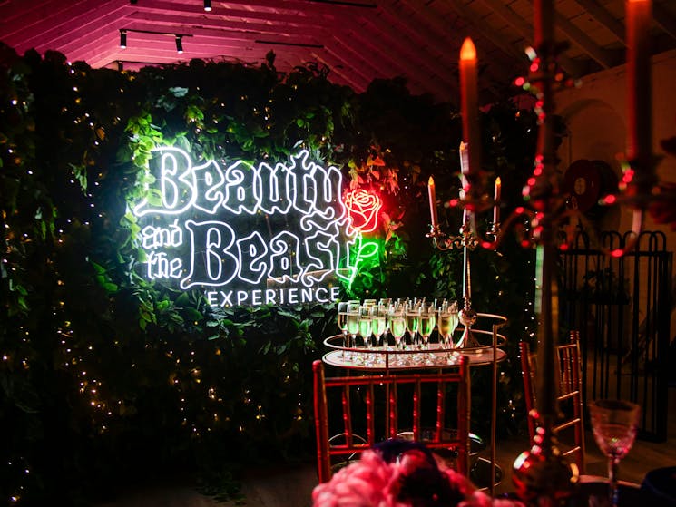 Beauty and the Beast neon sign with a bar cart of champagne