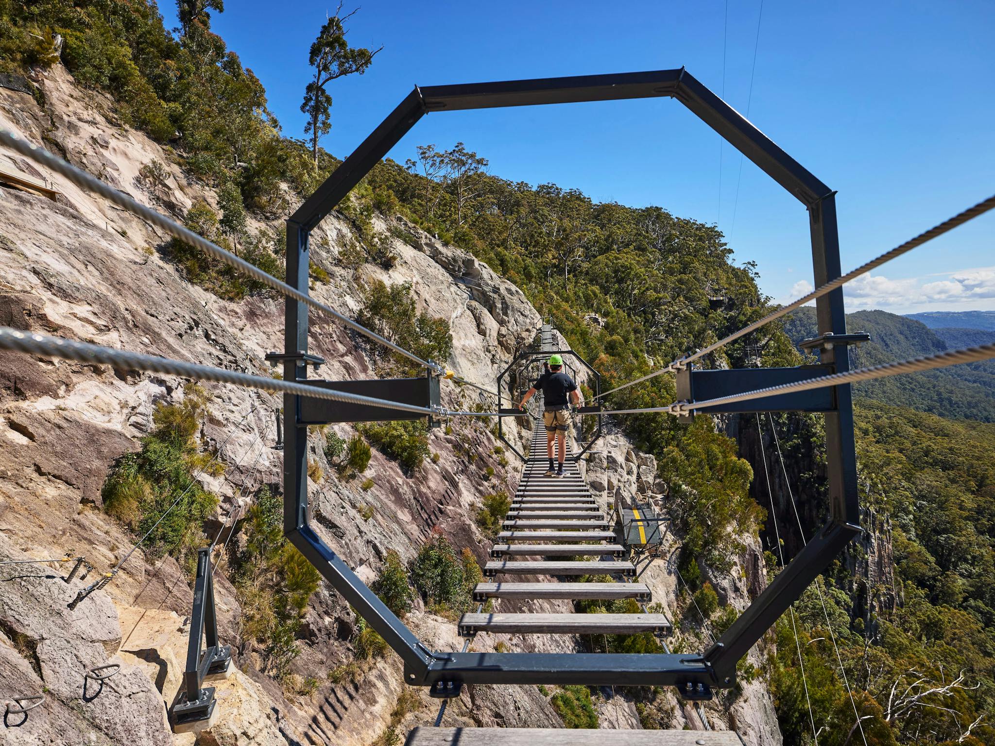 Man walking across Via Ferrata at Happitat Adventure Park Man walking across Via Ferrata at Happitat Adventure Park