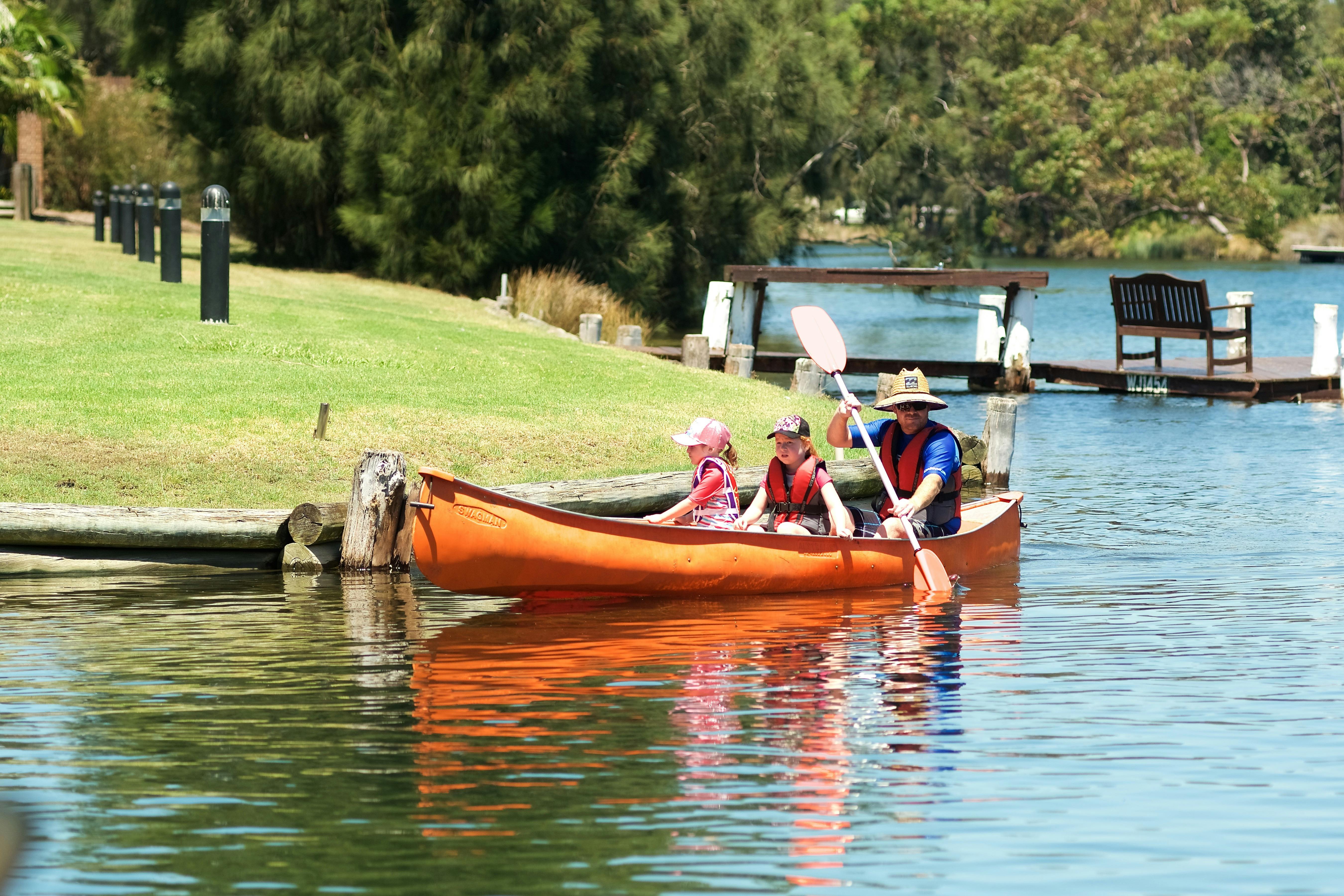 Guests canoeing in front of deluxe and wharf in back ground