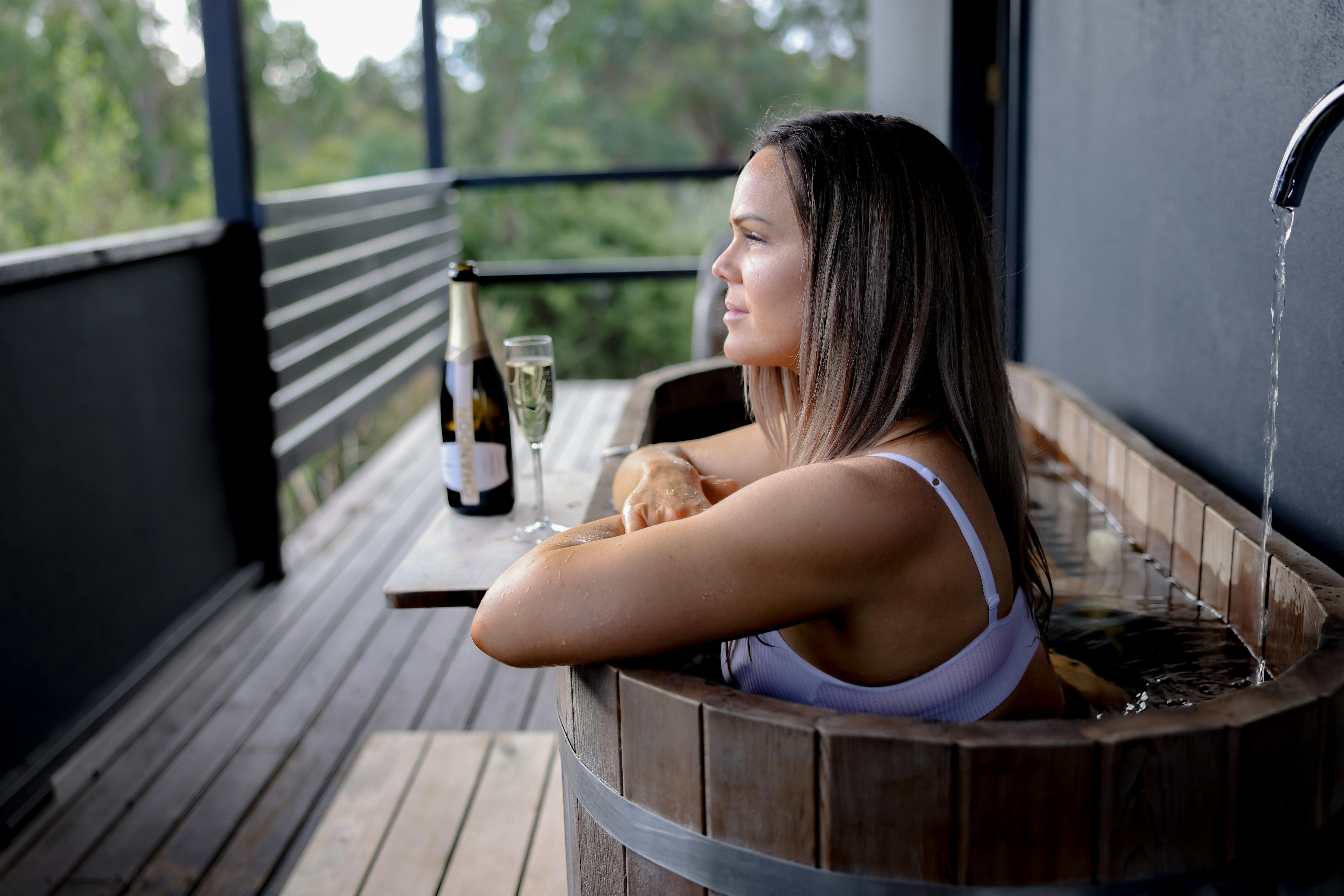 Lady enjoys a bath on the deck in the Bath Hideaway