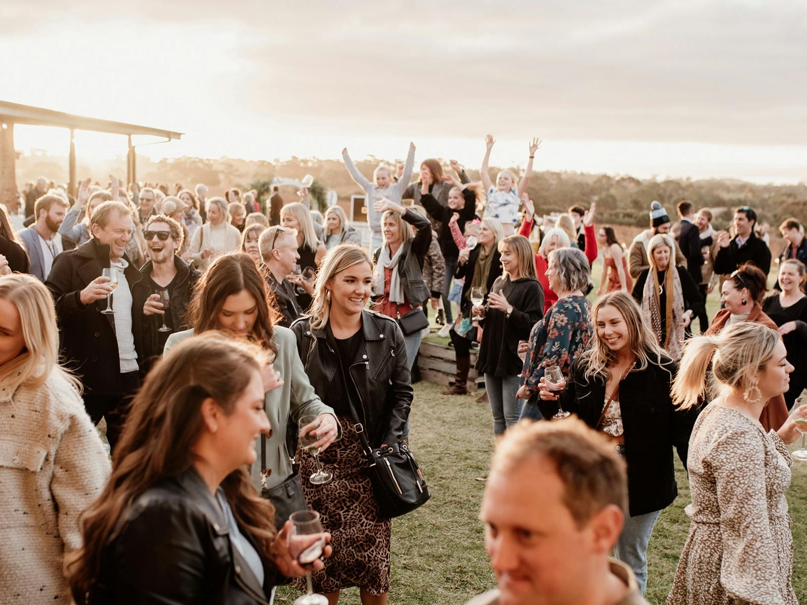 A crowd enjoys live music as the sun sets.