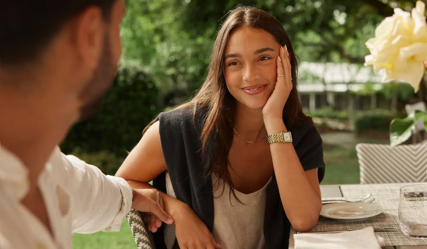 A close up of a couple sitting and looking at each other with a loving expression from the woman