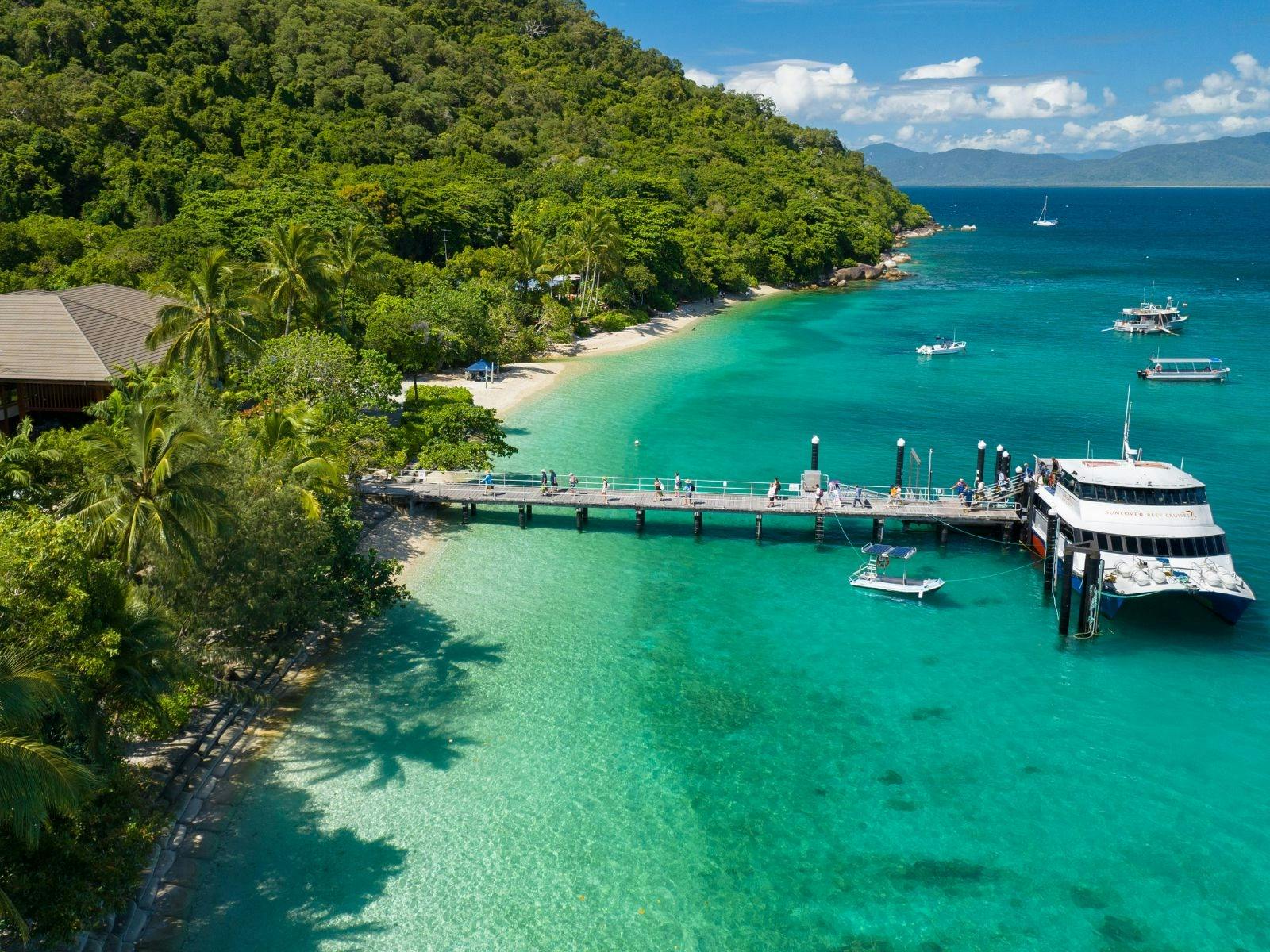 Sunlover Reef Cruises boat docked at the jetty on Fitzroy Island with tropical surroundings.
