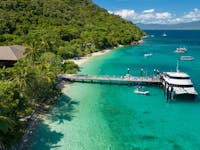 Sunlover Reef Cruises boat docked at the jetty on Fitzroy Island with tropical surroundings.