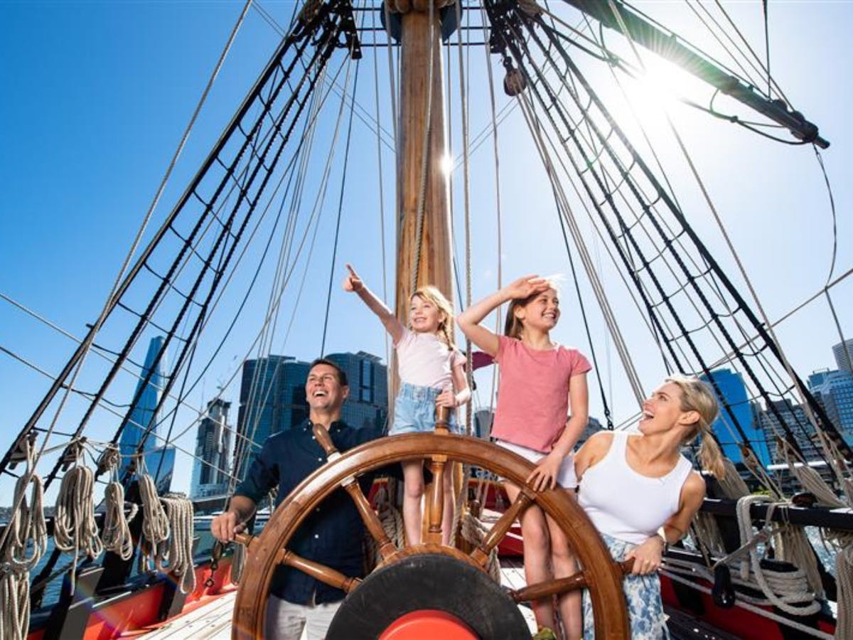 A family aboard a boat at the steering wheel enjoying themselves