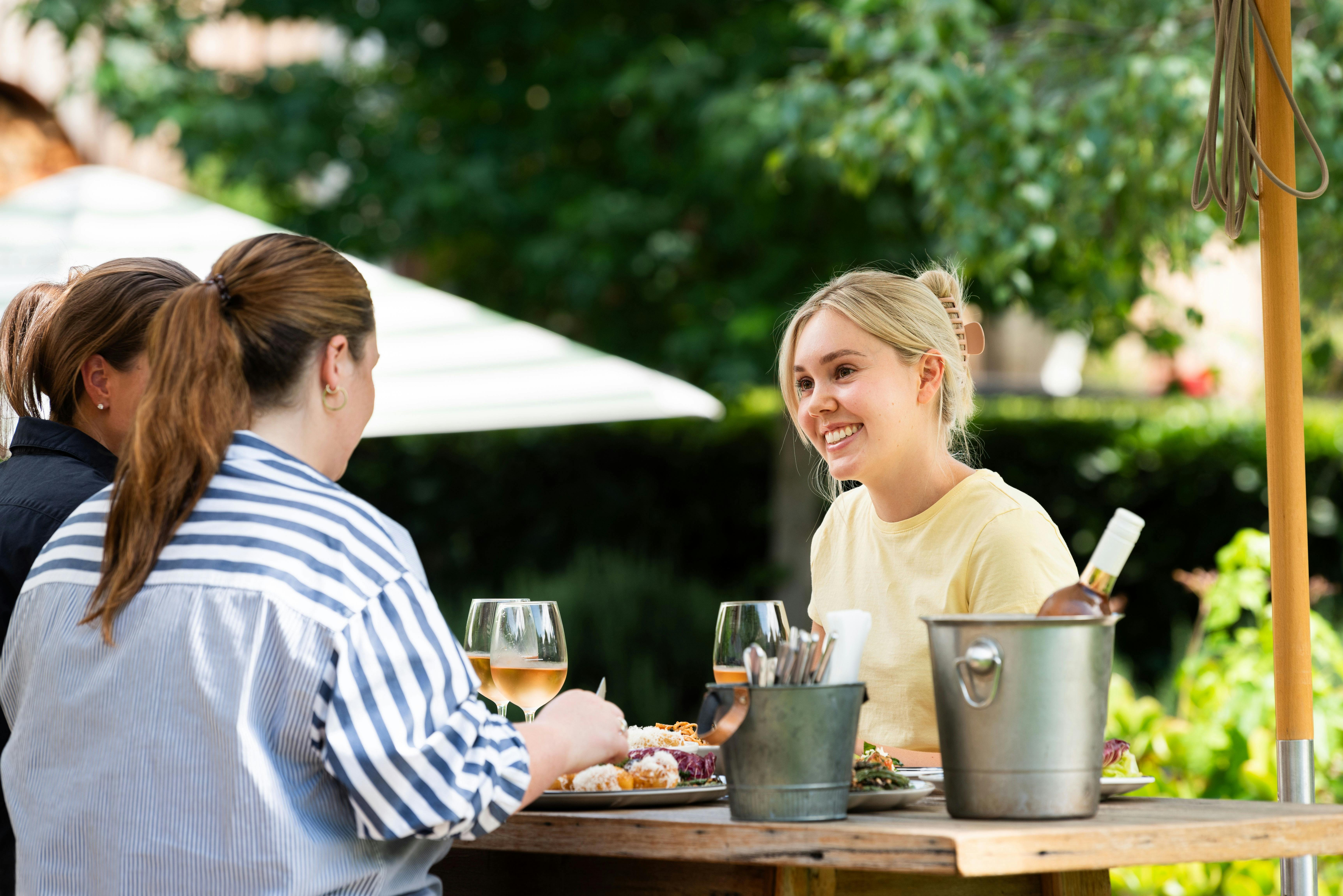 Table of three dining together in the outdoor area.