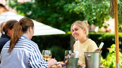 Table of three dining together in the outdoor area.