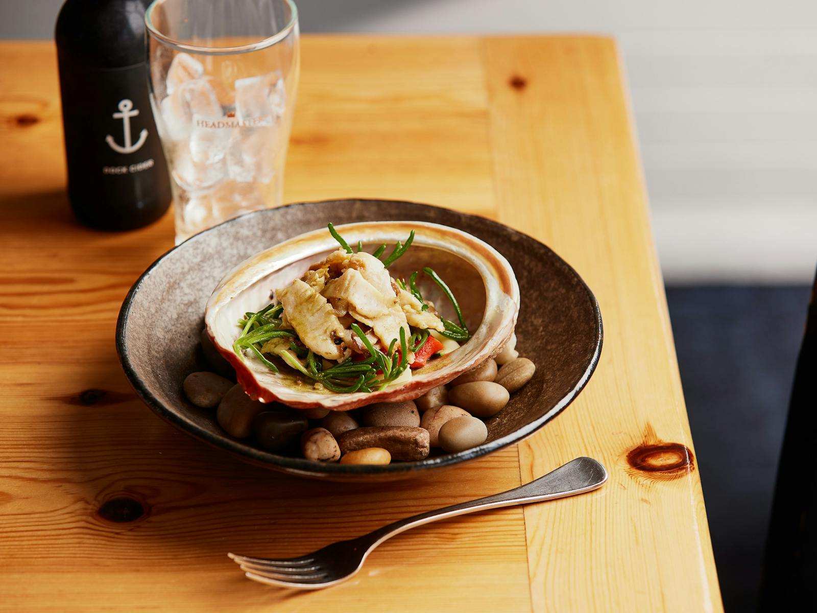 A plate showcasing Tasmanian Abalone meat, presented in an abalone shell.
