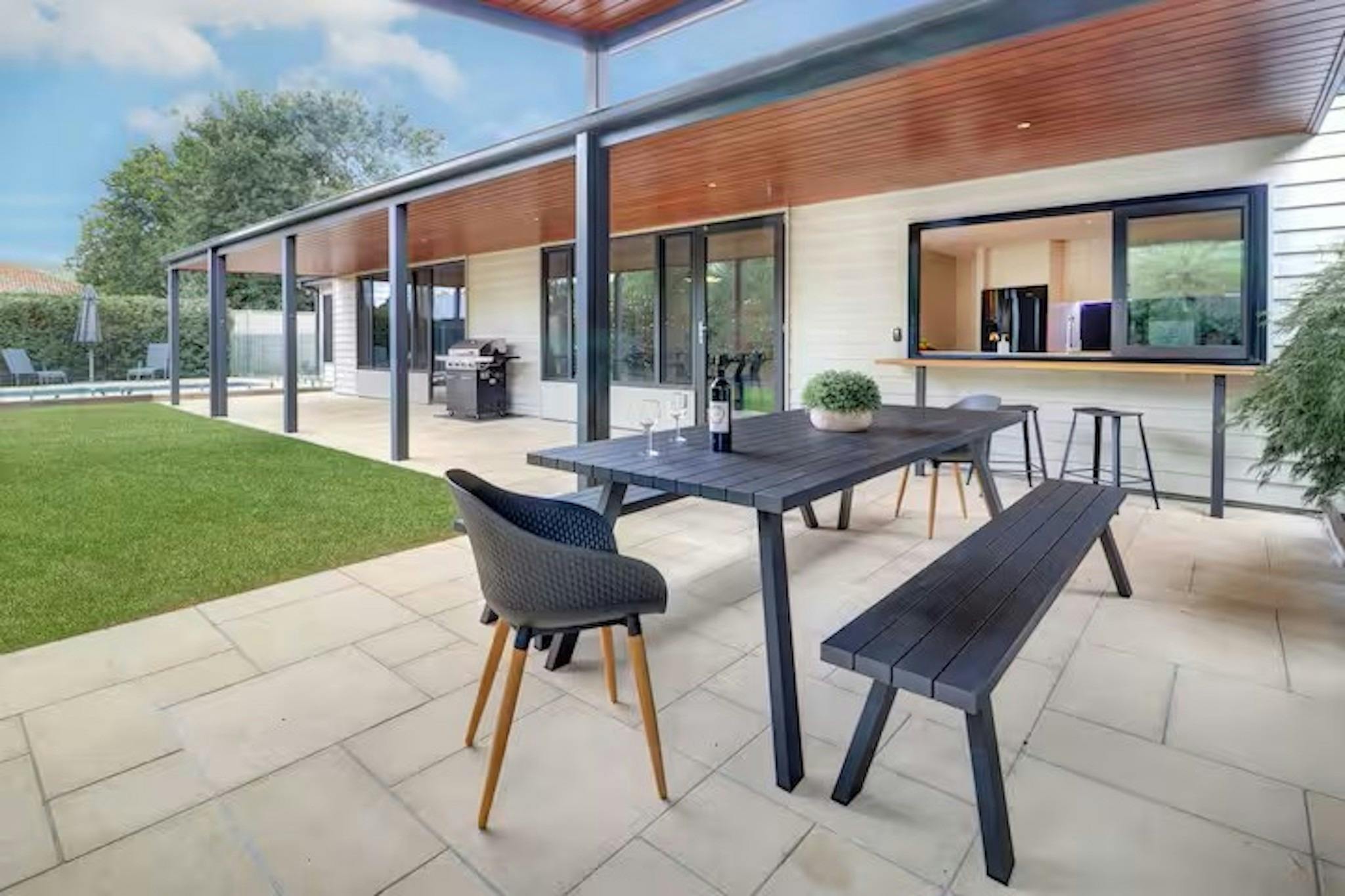 Covered outdoor dining and BBQ area at Banksia House holiday accommodation in Mansfield