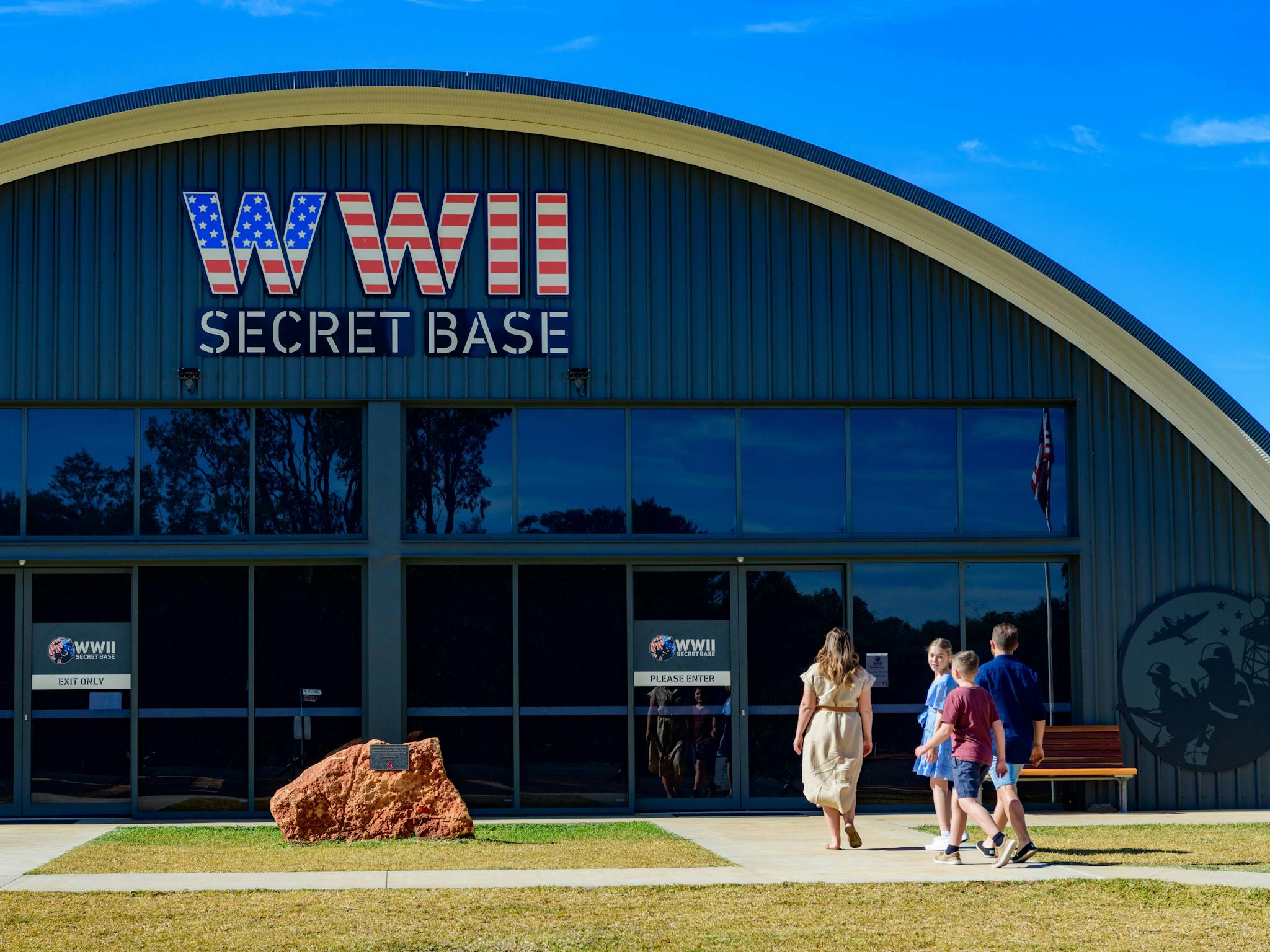 Front entrance of the base with a family of four walking towards the front entrance on a clear day Front entrance of the base with a family of four walking towards the front entrance on a clear day