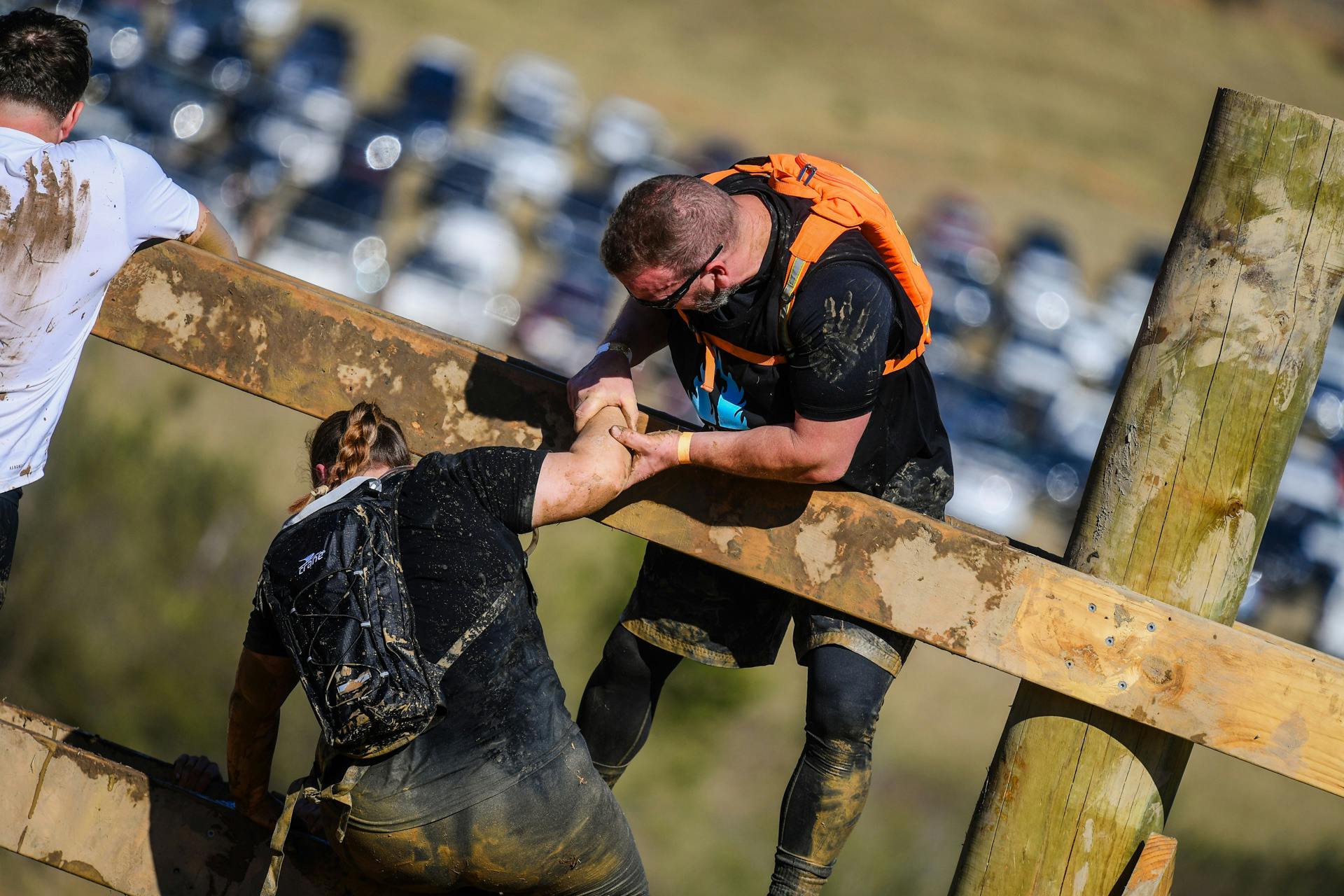 Racer helping another racer over an obstacle